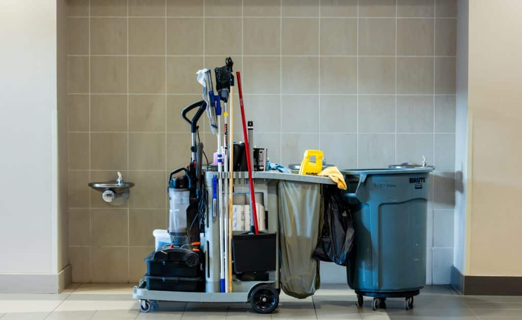 Chariot de Nettoyage Professionnel et Équipement de Ménage A comprehensive collection of professional cleaning tools on a cart in an indoor environment.